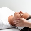 donna sdraiata che riceve un trattamento di Reiki